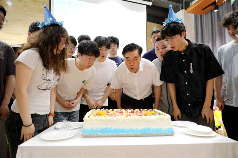 武汉轻工大学校长董仕节和毕业生一起吹生日蜡烛。吴云霄摄