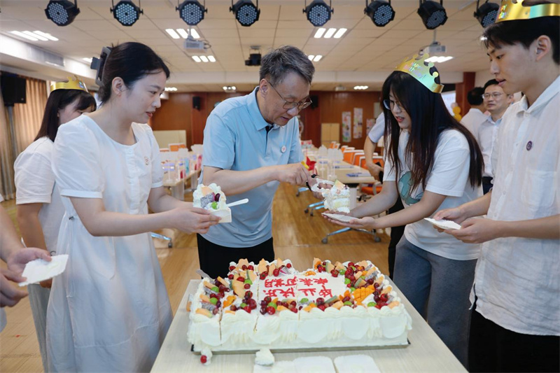 武汉轻工大学党委书记严冀钢给毕业生分发蛋糕。王月摄